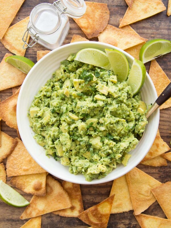 overhead shot of bowl of guac with tortilla chips surrounding