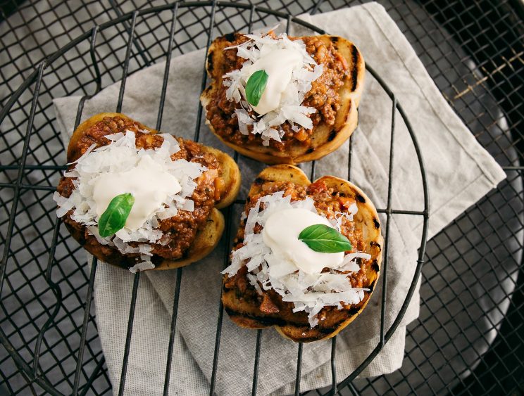 overhead shot of bolognese sliders on wire rack and napkin underneath