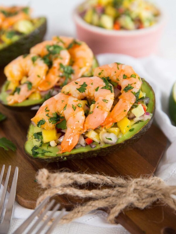 side shot of stuffed avocados lined up on chopping board