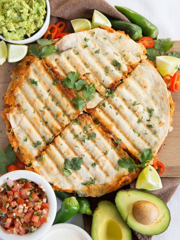 overhead shot of quesadillas sliced into 4 garnished with chilli, jalapeno and coriander