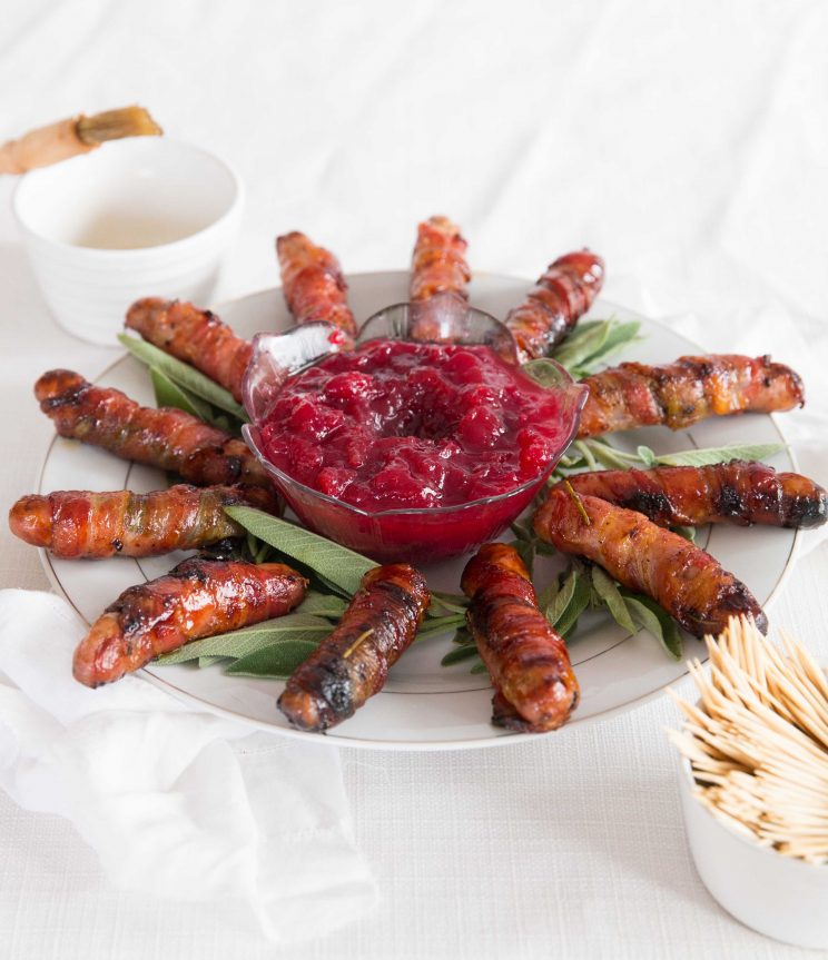 pigs in blankets circled around cranberry sauce on sage