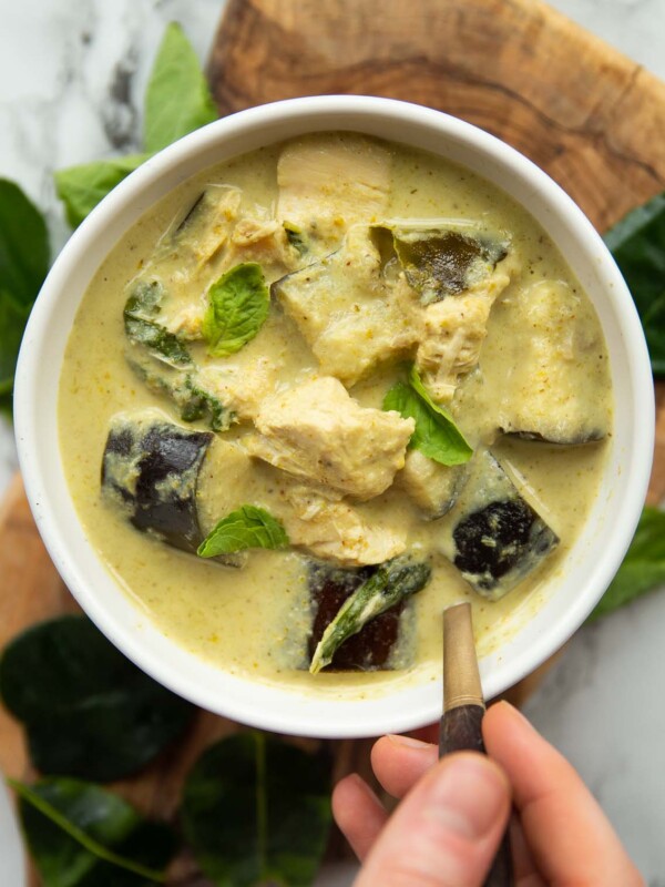 overhead shot of curry in white bowl with gold spoon digging in