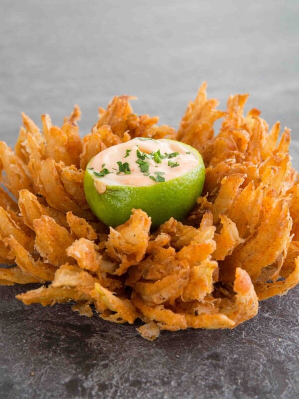 blooming onion served with lime dipping bowl in the centre on slate