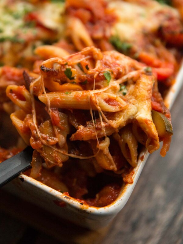 closeup shot of scooping pasta bake out of oven dish