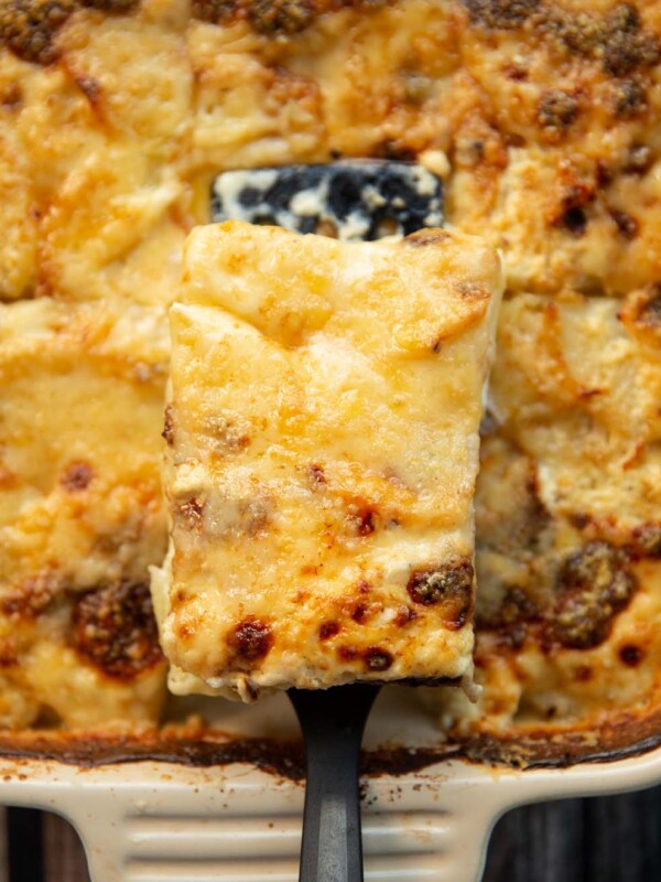 overhead shot of dauphinoise potatoes being scooped out of baking dish