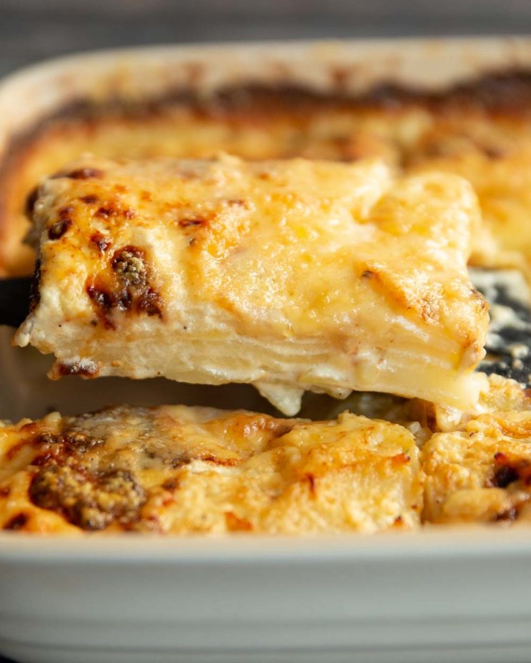 close up shot of dauphinoise being scooped from baking dish