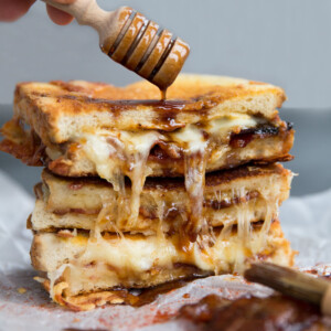 Grilled Cheese with honey dipper pouring over sauce