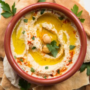 Bowl of hummus garnished with olive oil and paprika