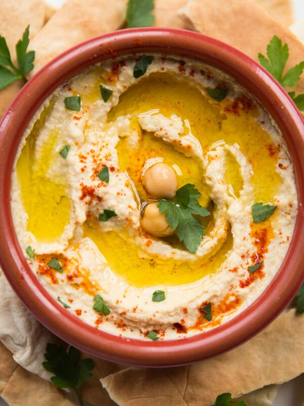 Bowl of hummus garnished with olive oil and paprika