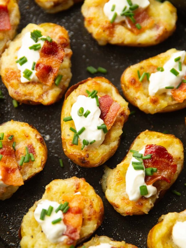 close up shot of mini loaded potatoes on black oven tray