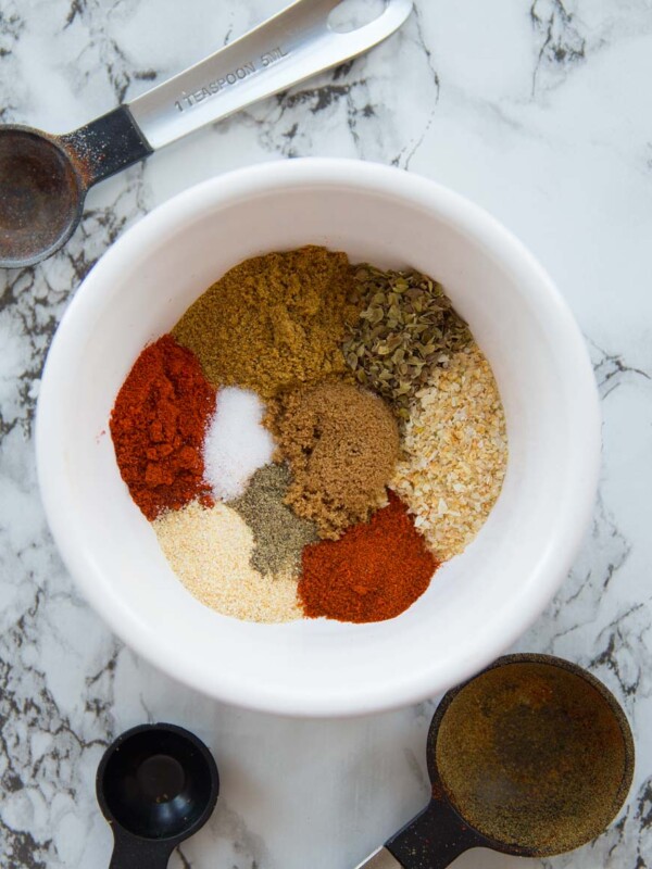 Small bowl with taco seasoning surrounded by measuring spoons