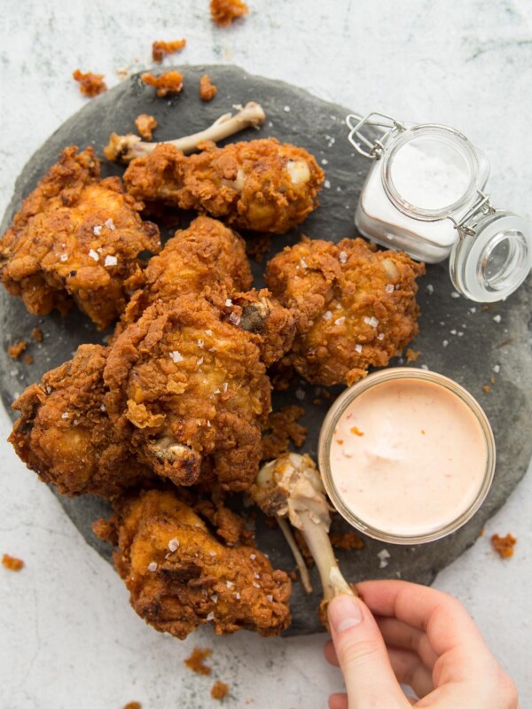 Crispy Buttermilk Fried Chicken on a grey slate with dip and salt