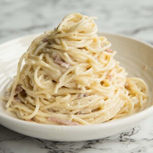 Cream Cheese Pasta served on a curved white plate on a marble surface