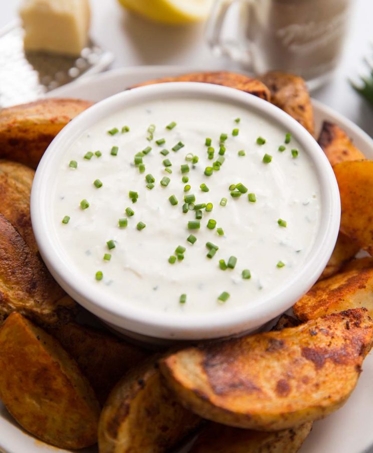 dip circled by homemade wedges with lemon wedges in the background