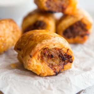 Pork and Chorizo Sausage Roll on baking paper with 4 in the background