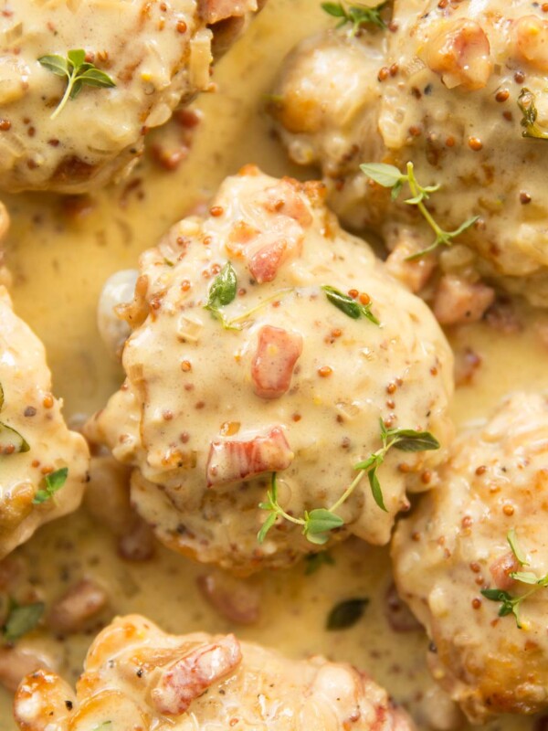 overhead shot of thighs and sauce in a skillet garnished with fresh thyme