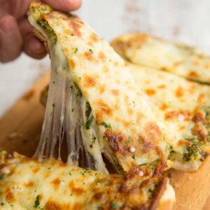 Pull one slice of garlic bread away from loaf with cheese pulling away