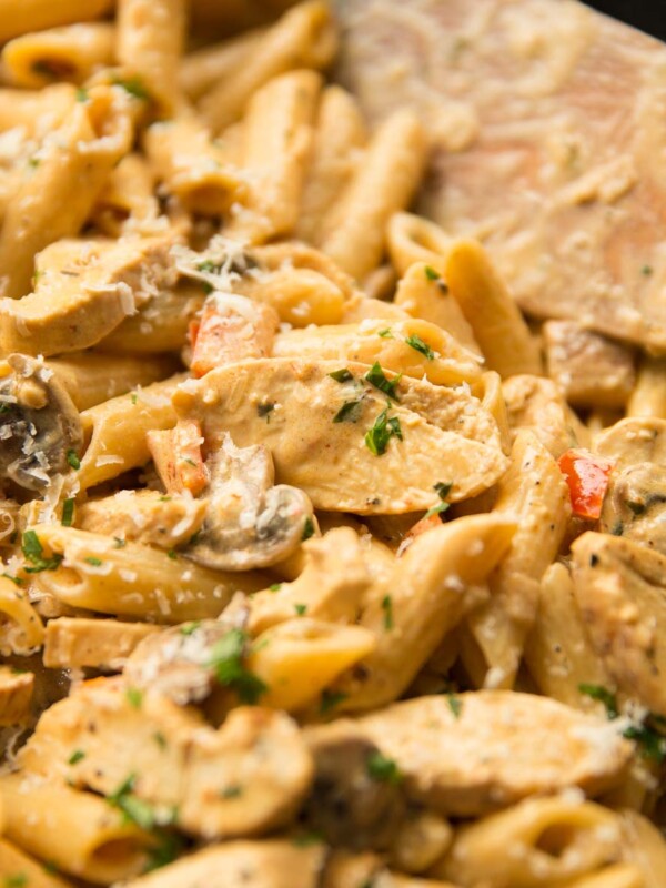 cajun chicken pasta in a skillet with wooden spoon blurred in background