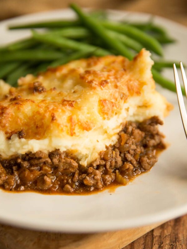 shepherd's pie plated up with green beans blurred in the background