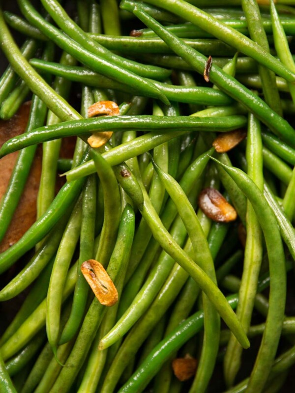 overhead shot of green beans in pan with crispy bits of garlic