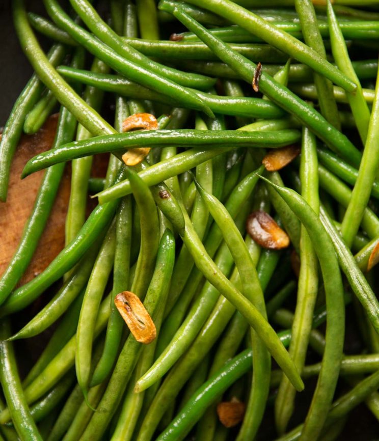 overhead shot of green beans in pan with crispy bits of garlic