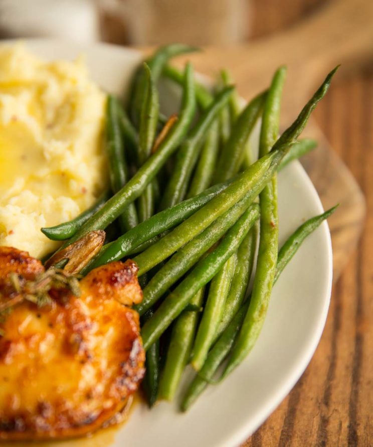 green beans on a plate with chicken and mash