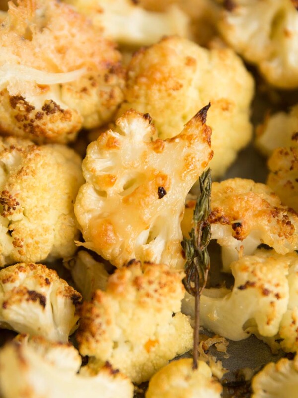 closeup shot of parmesan roasted cauliflower on baking tray with thyme