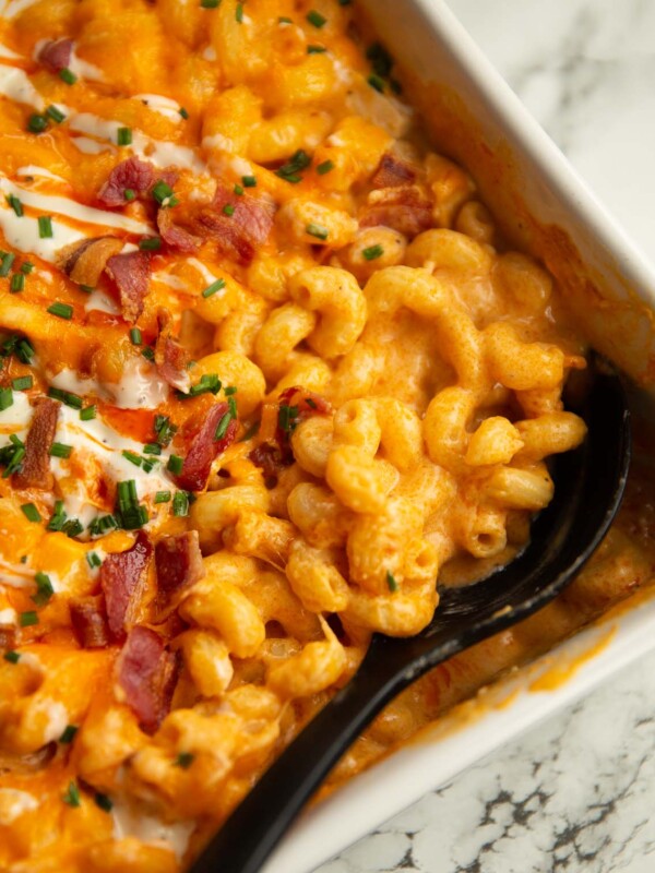 close up shot of serving spoon digging in to baked buffalo chicken mac and cheese fresh out the oven