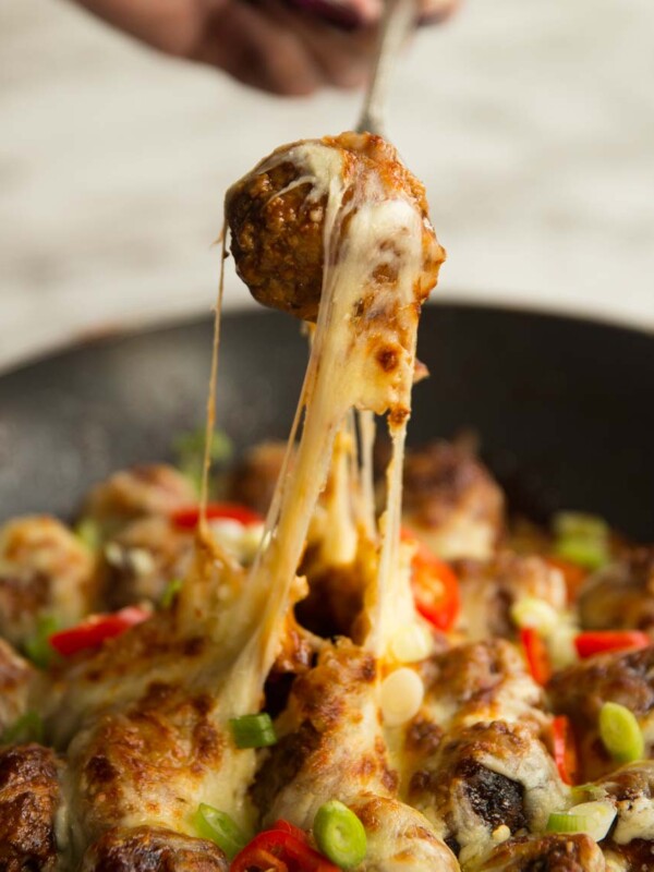 pull meatball out of skillet with fork and cheese dripping down