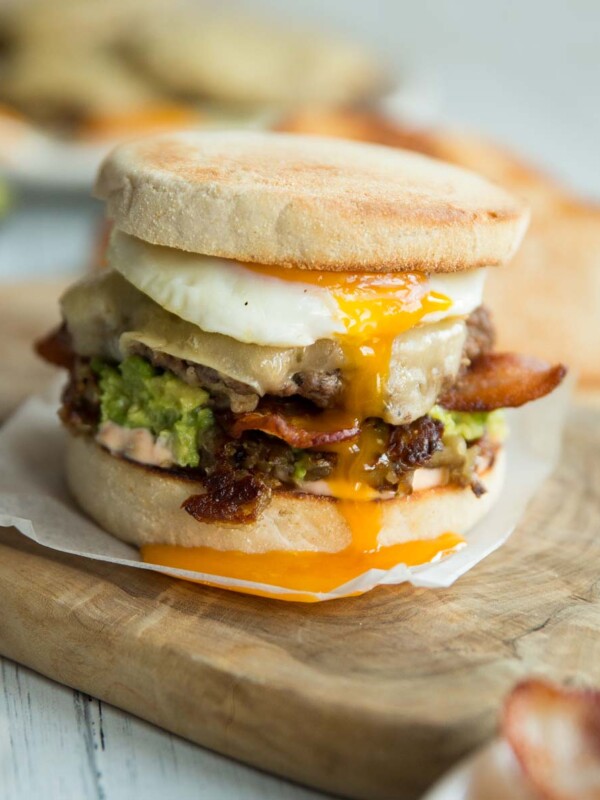 breakfast burger with yolk dripping down on chopping board