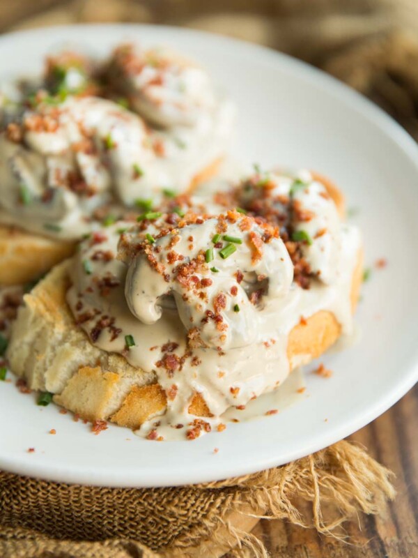 creamy mushrooms on two slices of toast with bacon and chives