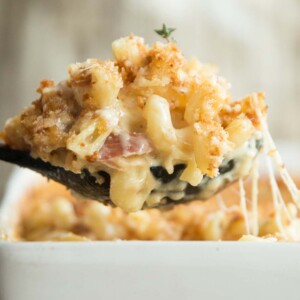 large spoonful of mac and cheese scooped out of baking dish