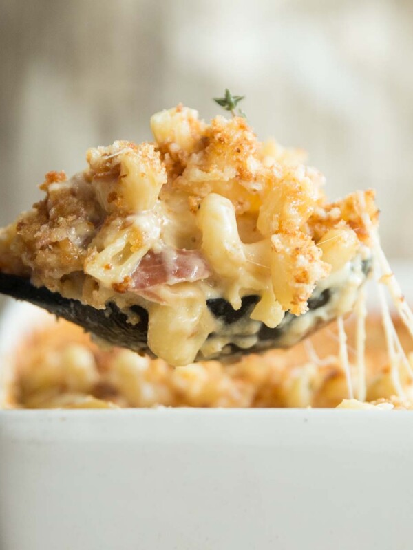 large spoonful of mac and cheese scooped out of baking dish