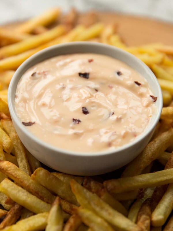 closeup shot of sweet chilli mayo in pot surrounded by fries