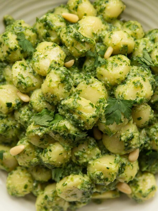 overhead shot of gnocchi pesto in white bowl