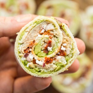 closeup shot of chicken avocado pinwheel with more blurred in the background