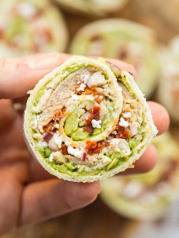 closeup shot of chicken avocado pinwheel with more blurred in the background