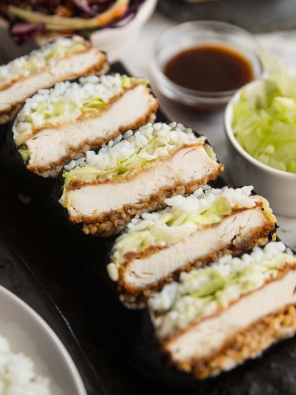 sushi sandwiches stacked on long plate with garnish surrounding