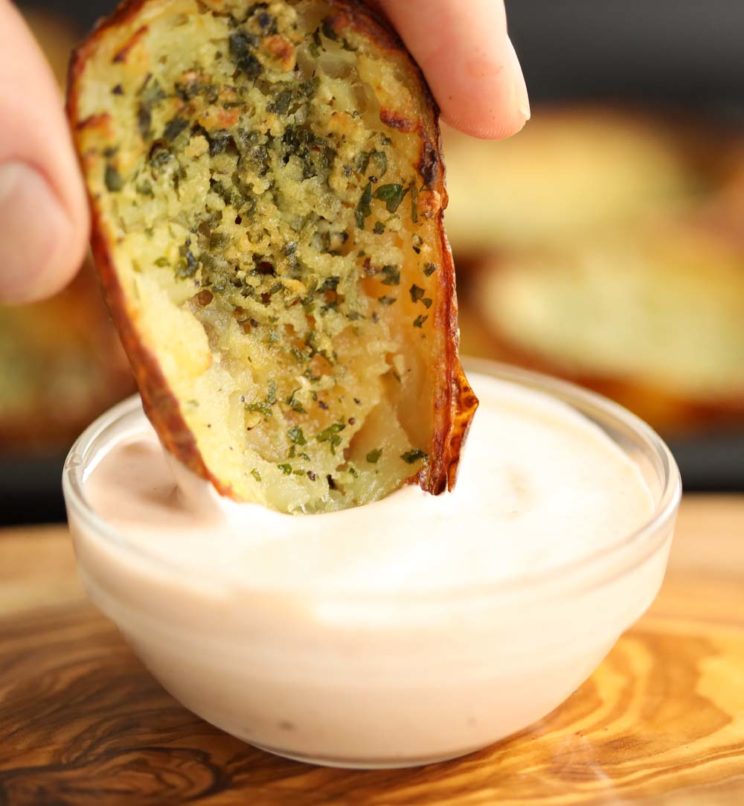 dipping potato skin into pot of sour cream