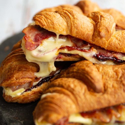 croissants stacked on one another with brie dripping off of top one