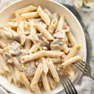 overhead shot of pasta in white bowl with two forks resting on it