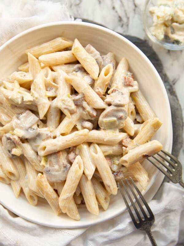 overhead shot of pasta in white bowl with two forks resting on it