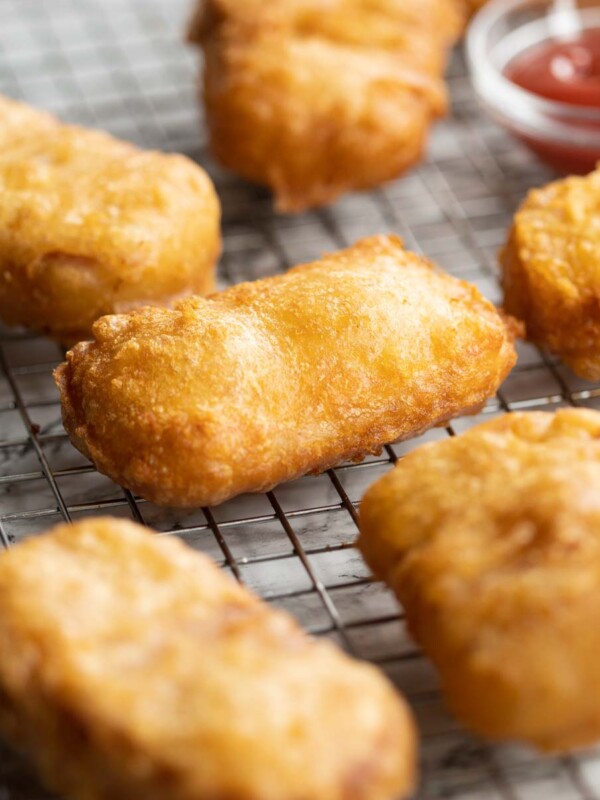 fritters fresh out the fryer on wire rack with ketchup blurred in background