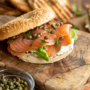 open top bagel surrounded by ingredients and more bagels blurred in the background