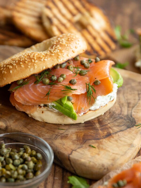 open top bagel surrounded by ingredients and more bagels blurred in the background