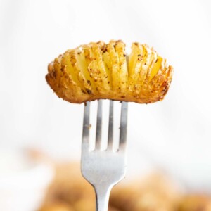 mini potato on end of fork with white background