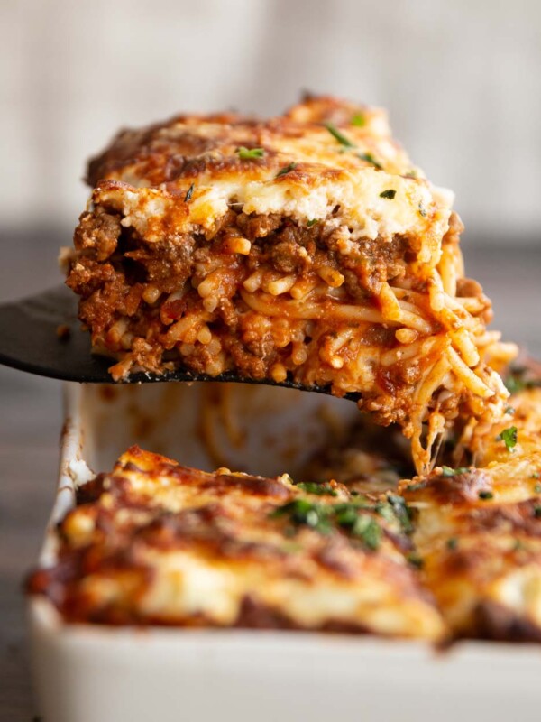 spatula lifting spaghetti from casserole dish