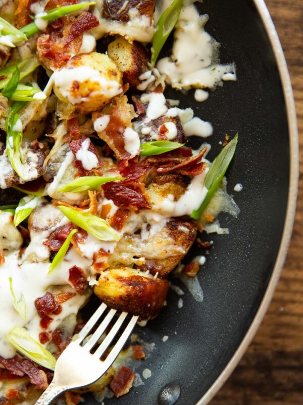 overhead shot of fork digging into potatoes in skillet