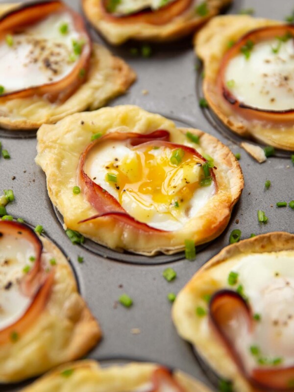 closeup shots of egg cups in muffin tin garnished with chives