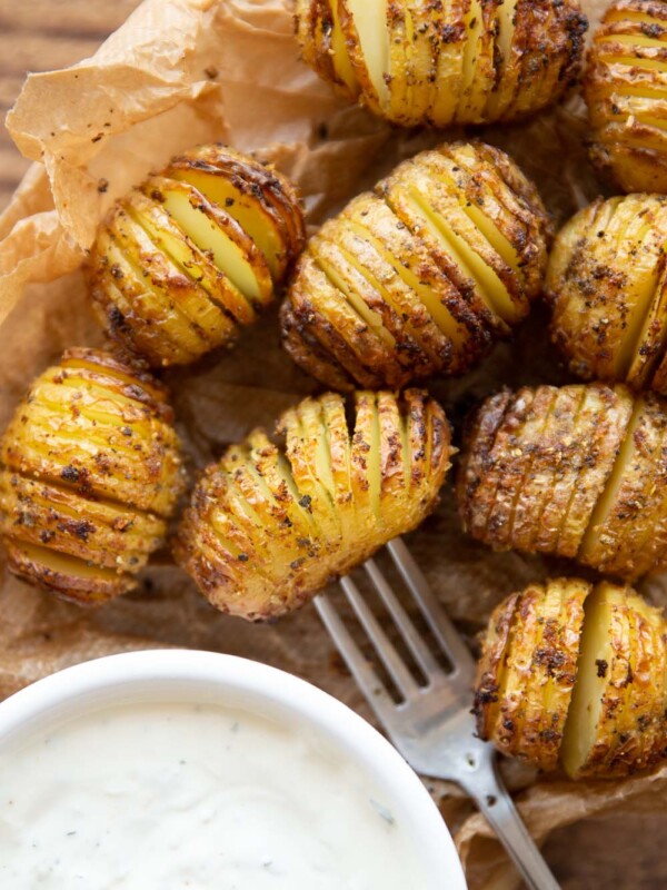 overhead shot of potatoes on brown parchment paper with dip in corner